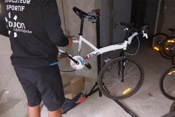 éducateur sportif réparant un vélo de l'école