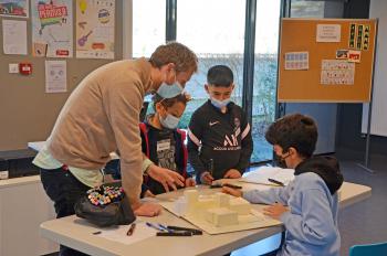 En groupe et accompagnés d'un architecte, les enfants réalisent une maquette de leur école idéale